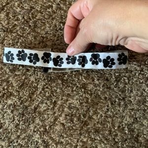 White stretchy headband with black paw prints